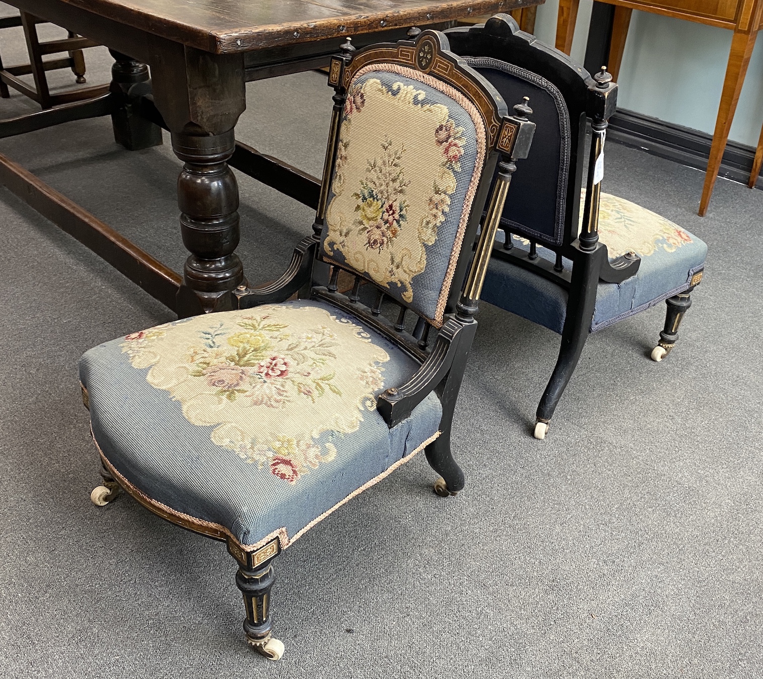 A pair of late Victorian ebonised and amboyna salon chairs with petit point upholstery, width 50cm, height 82cm